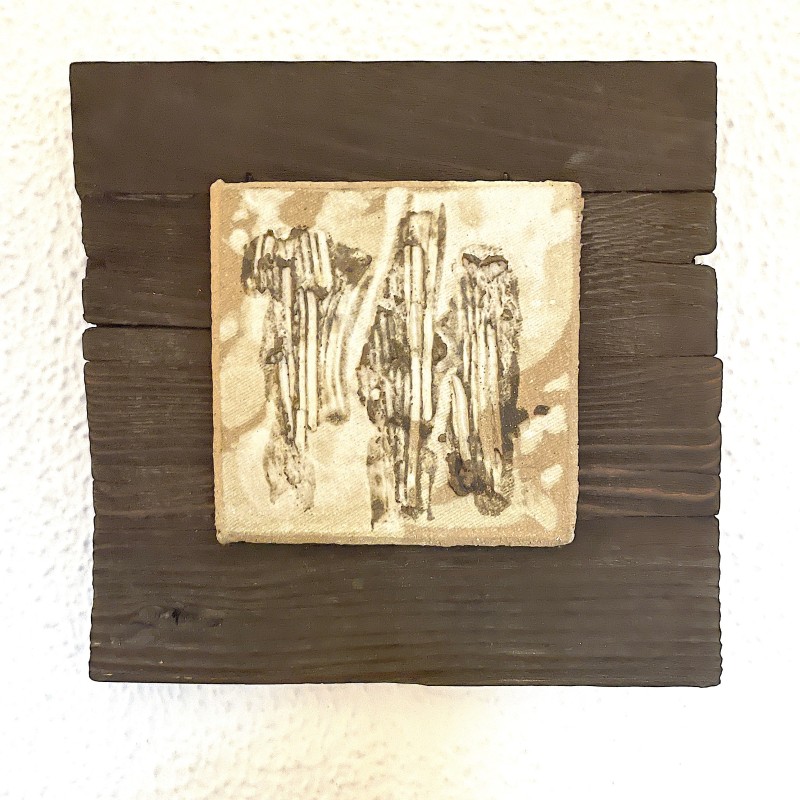 Ceramic relief featuring three abstract striated vertical columns on a dark wood panel by Ismael Garcia Burillo