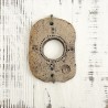 Relieve cerámico de placa de gres perforada con marcas cardinales sobre madera blanca de Ismael García Burillo